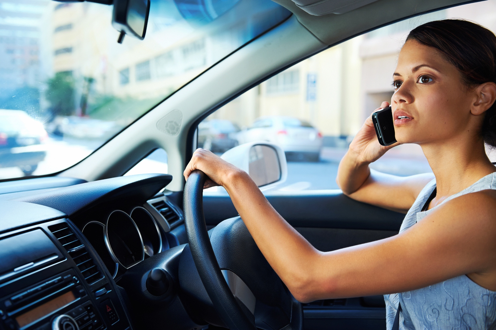 Stock image of a woman talking on a cell phone while driving