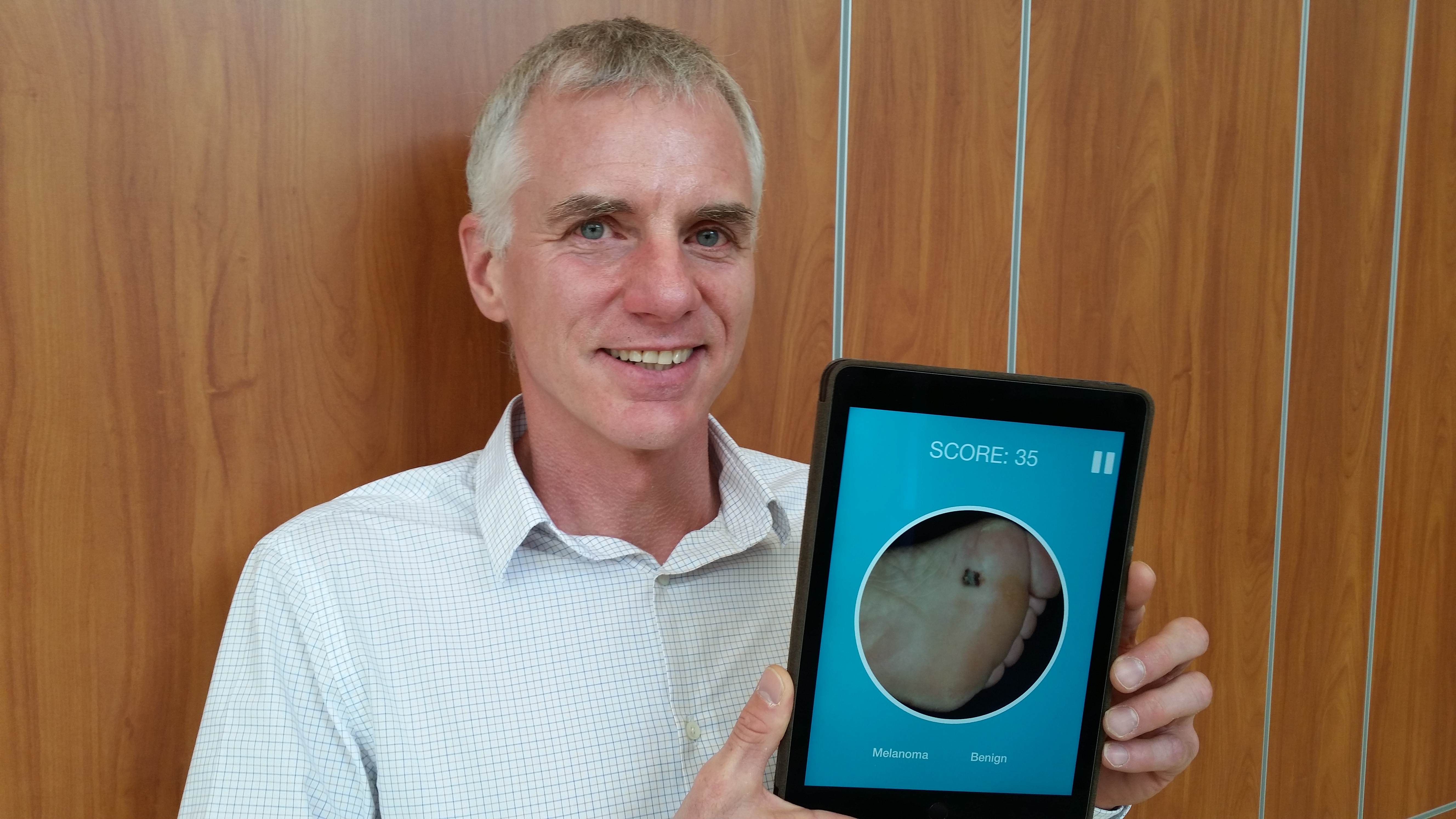 Liam Rourke shows an Ipad app that's been developed to help train health professionals to identify skin lesions