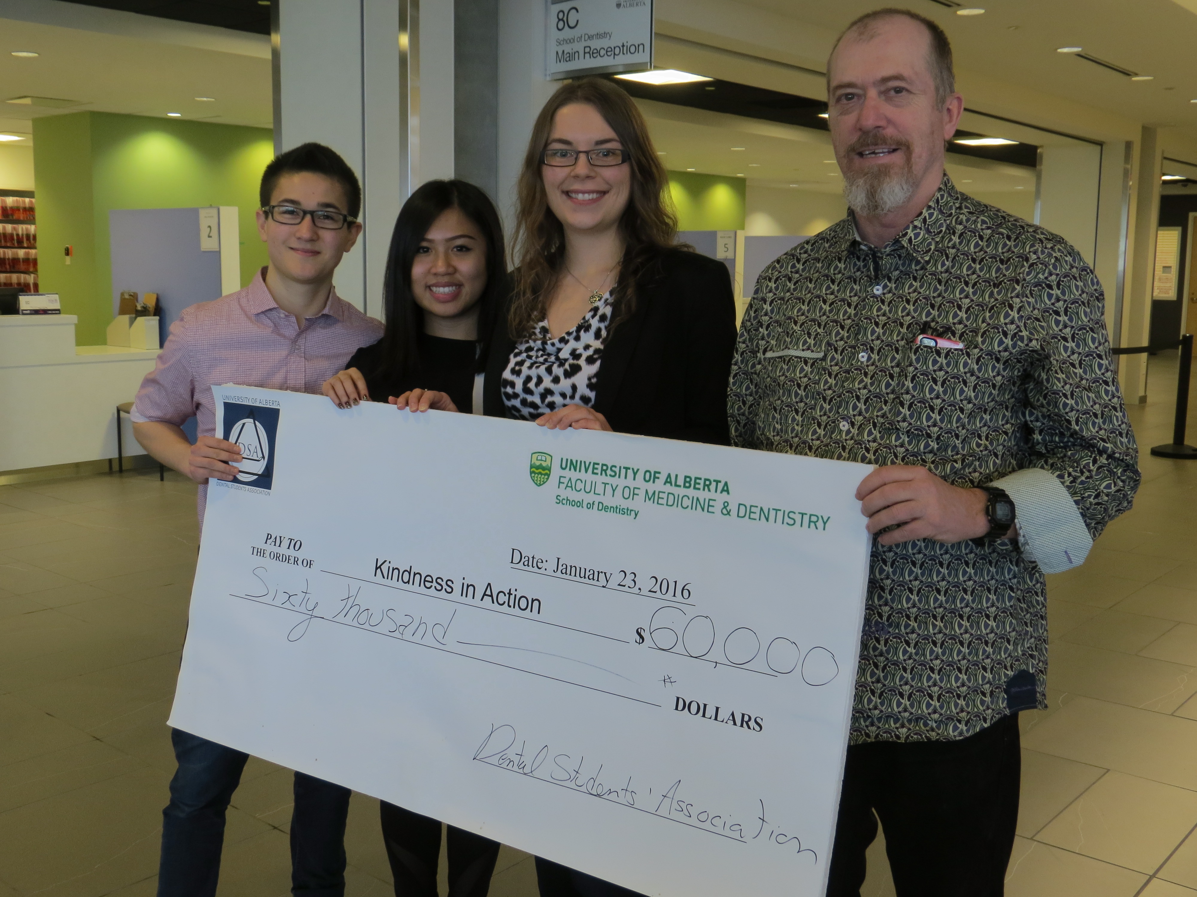 First year School of Dentistry students Nicholas Churchill, Brenda Pham and Emily Ervin present a $60,000 cheque to Kindness in Action vice-president Dave Maskell.