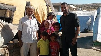Saleem Al-Nuaimi poses with a family during a trip to Syria